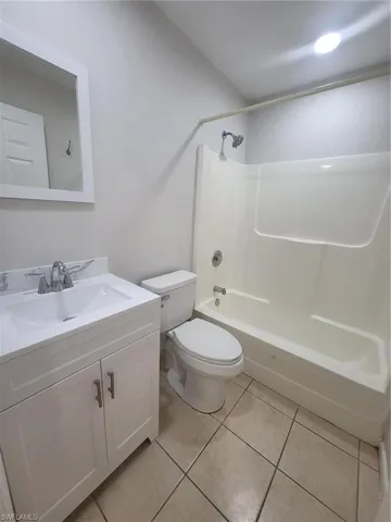 Full bathroom featuring vanity, light tile patterned floors, and tub / shower combination