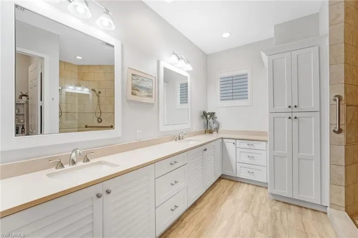 The beautifully remodeled primary ensuite bath features sleek quartz countertops and custom cabinetry, offering a sophisticated, clean-lined design.