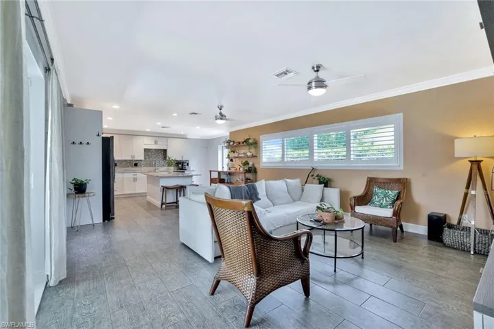 Living room with ceiling fan and ornamental molding