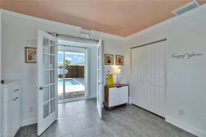 Bedroom with a closet, crown molding, french doors, access to exterior, and hardwood / wood-style flooring