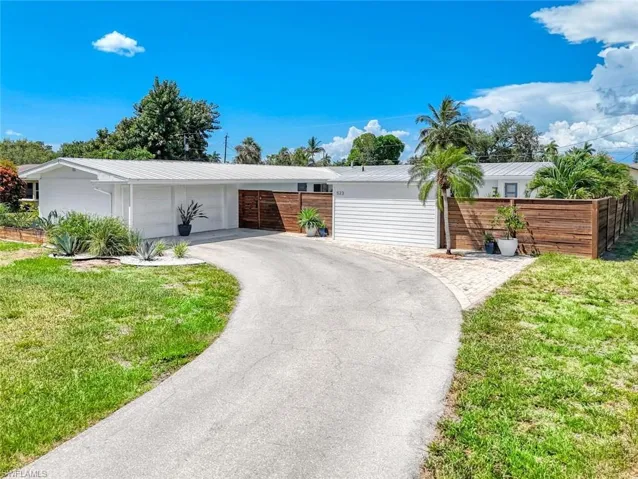 Single story home featuring a garage and a front lawn