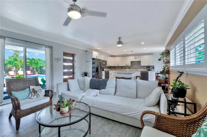Living room with crown molding and ceiling fan