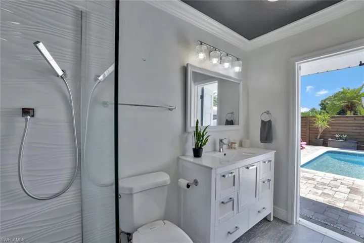 Bathroom with a healthy amount of sunlight, vanity, toilet, and ornamental molding