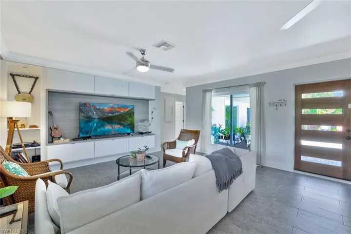 Living room with crown molding and ceiling fan