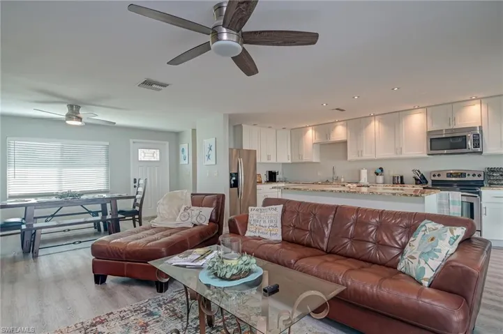 Living room featuring light wood-style floors, a ceiling fan, and recessed lighting