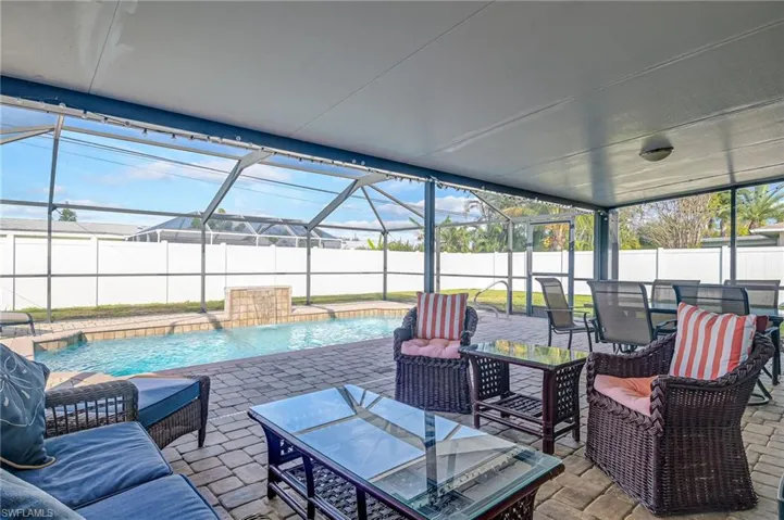 Fenced backyard with a sunroom, a patio, a lanai, and an outdoor living / dining area