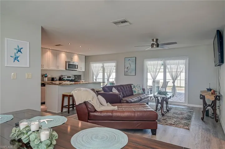 Living room with wood finished floors, a ceiling fan, and recessed lighting