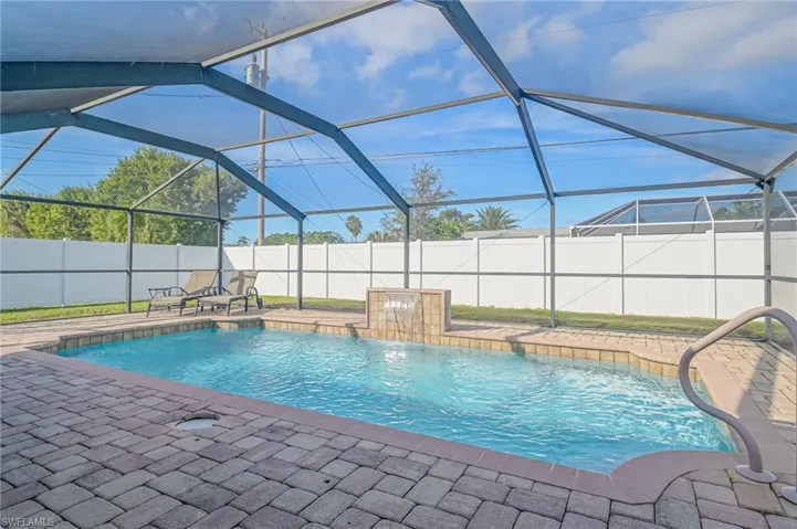 View of swimming pool with a fenced backyard, a sunroom, and glass enclosure