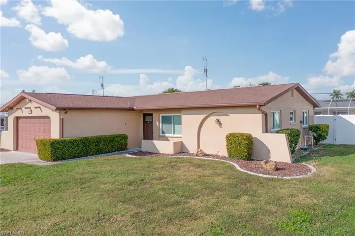 Ranch-style home with stucco siding, an attached garage, a front lawn, and concrete driveway