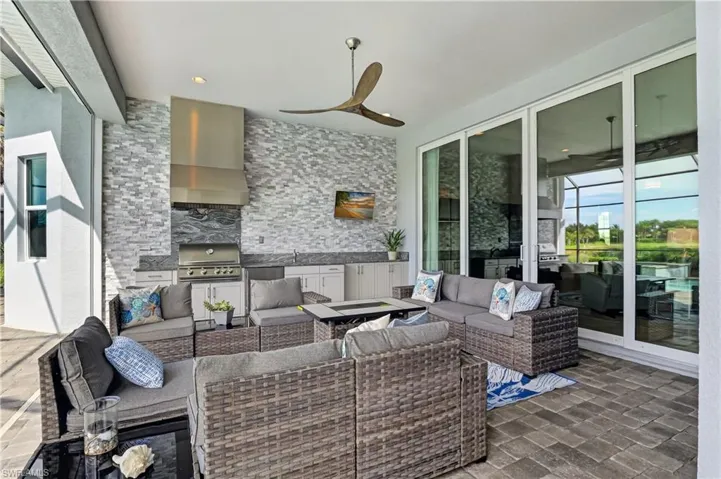 Wall along outdoor kitchen recently finished with textured stone tiles.