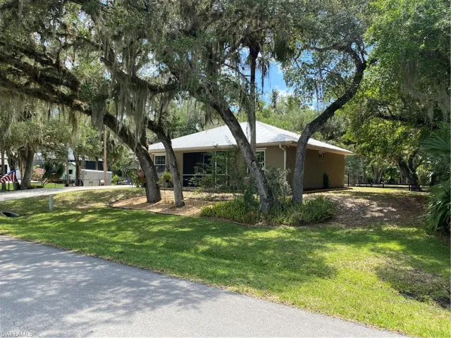 View of front of home featuring a front yard, driveway, and stucco siding