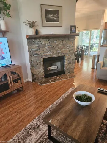 Living area with wood finished floors and a stone fireplace
