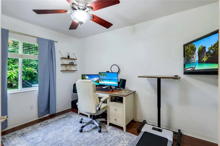 Office area with dark hardwood / wood-style floors and ceiling fan