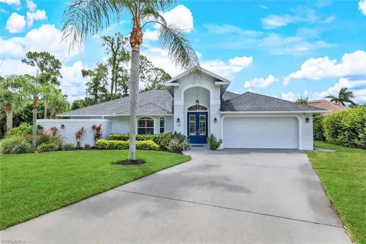 View of front of home with a garage and a front lawn