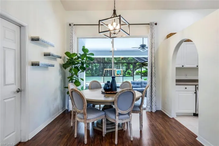 Tiled dining room with ceiling fan with notable chandelier