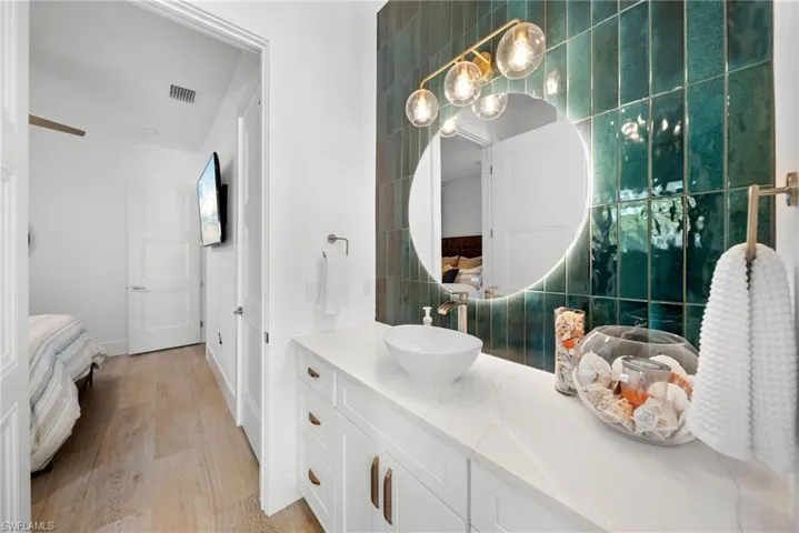 Ensuite bathroom with vanity and light wood-style floors