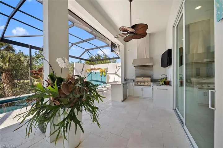 View of patio featuring a sunroom, a lanai, area for grilling, a ceiling fan, and an outdoor pool