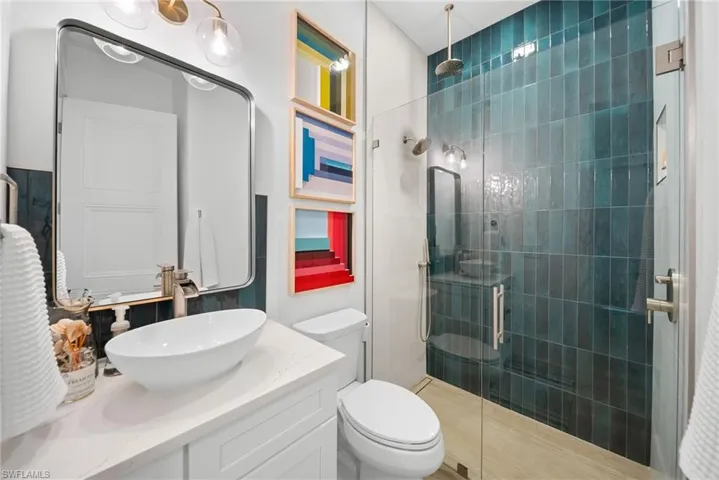 Full bath featuring a stall shower and vanity