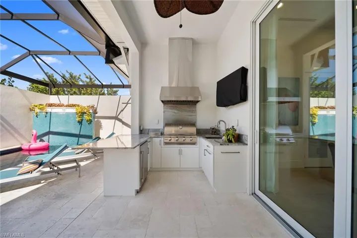 View of patio / terrace with a sunroom, glass enclosure, an outdoor kitchen, and ceiling fan