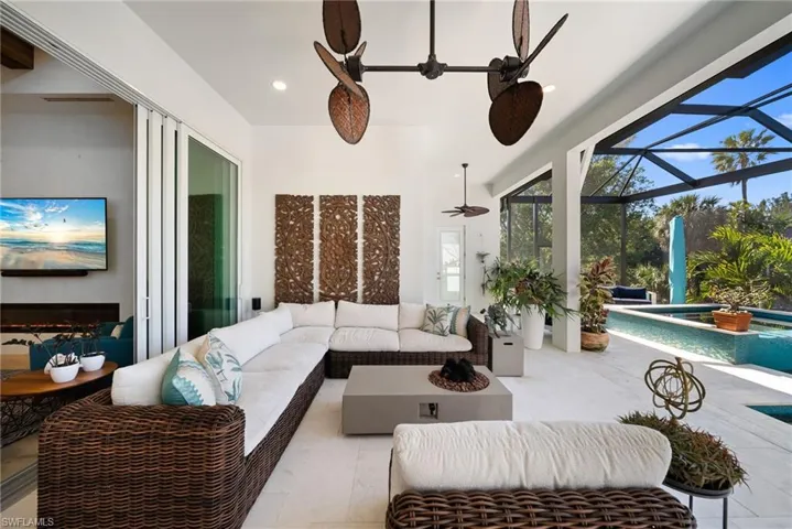 View of patio / terrace with an outdoor living space, a sunroom, a lanai, a ceiling fan, and a pool with connected hot tub