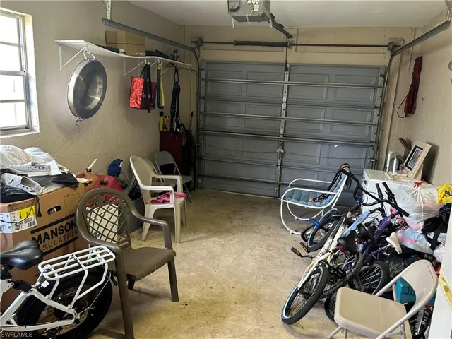 Garage with a textured wall and a garage door opener