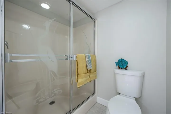 Bathroom with walk in shower, tile patterned floors, and toilet