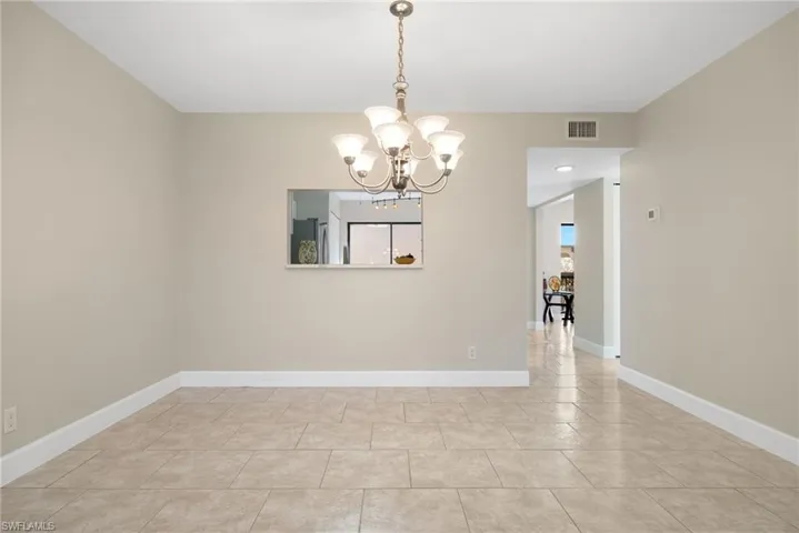 Tiled empty room with a chandelier