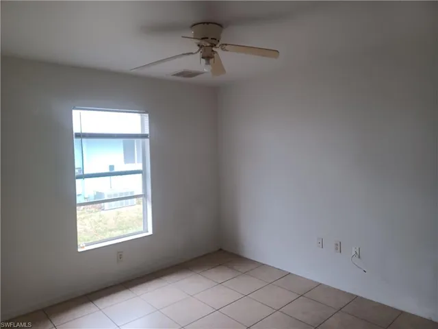 Spare room featuring a ceiling fan and light tile patterned floors