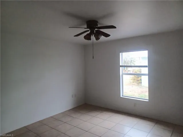 Spare room with a ceiling fan and light tile patterned flooring