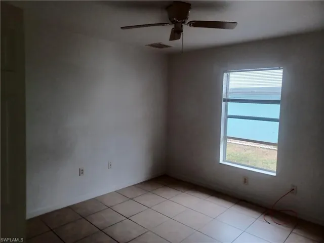 Unfurnished room featuring a ceiling fan and light tile patterned flooring