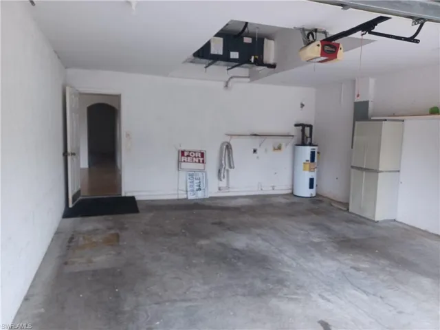 Garage with electric water heater and a garage door opener