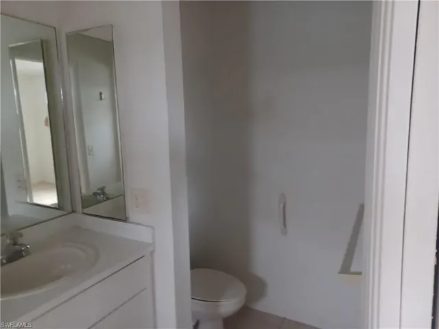 Half bathroom featuring vanity and light tile patterned flooring