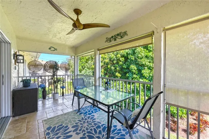 Sunroom featuring ceiling fan, outdoor dining area, and a balcony