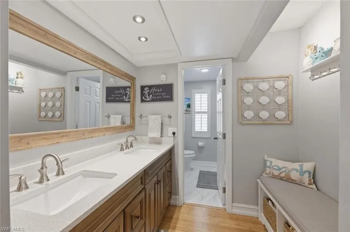 Full master bathroom with double vanity, recessed lighting, and light wood-type flooring