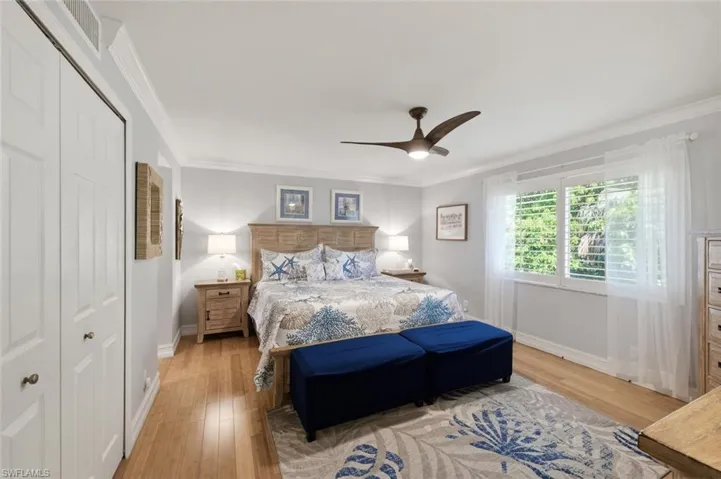 Master Bedroom with ornamental molding, light wood-style flooring, a closet, and a ceiling fan