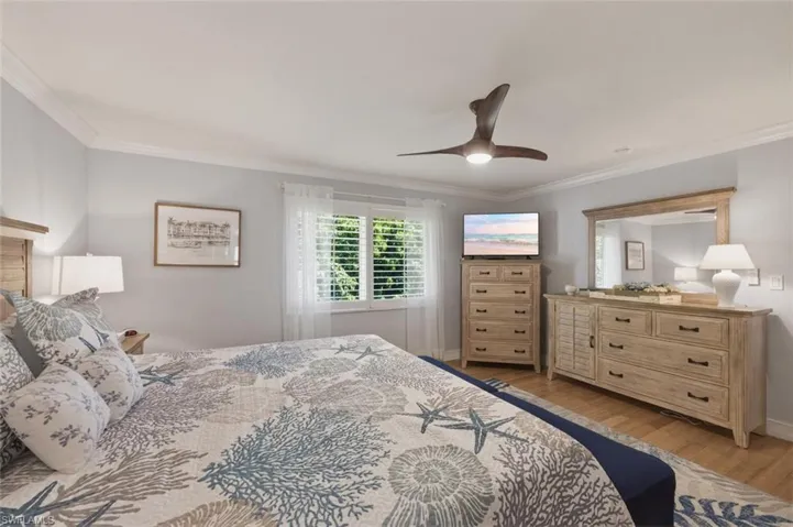 Master Bedroom with crown molding, light wood finished floors, and ceiling fan