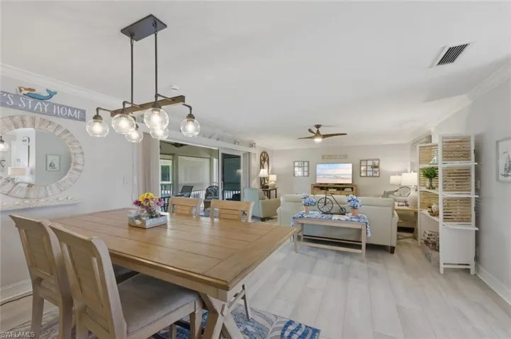 Dining space featuring crown molding, light wood-type flooring, and a ceiling fan