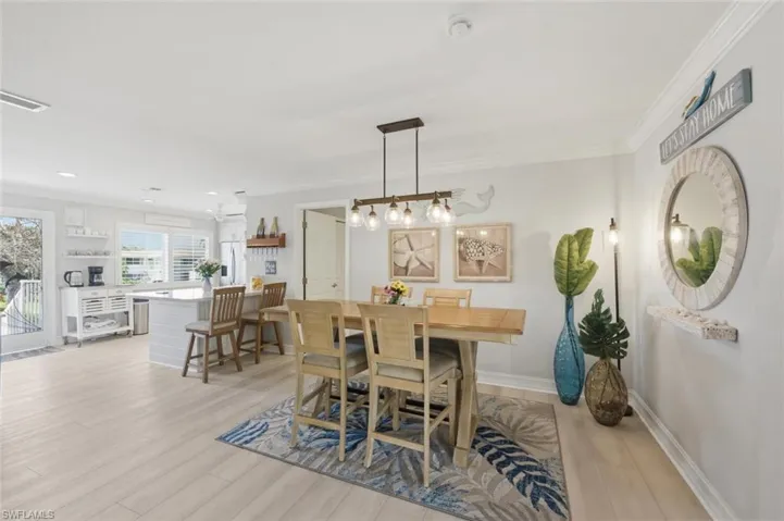 Dining space with crown molding and light wood-type flooring