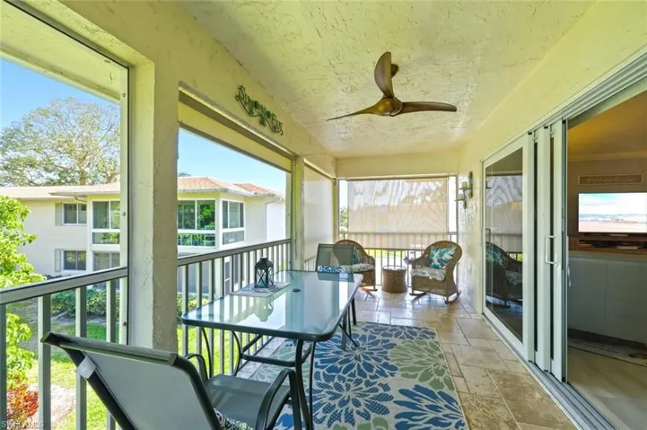 Sunroom with a ceiling fan and a balcony