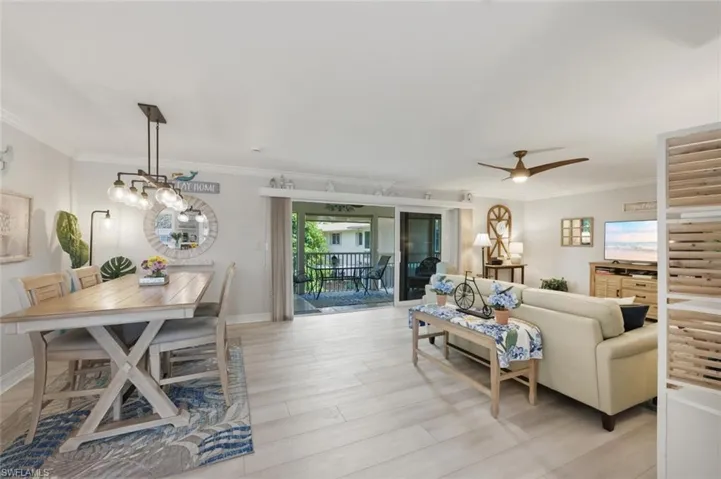 Living area with light wood-style flooring, crown molding, and a ceiling fan