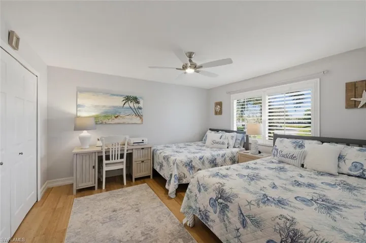 Guest Bedroom with a closet, light wood-type flooring, and ceiling fan