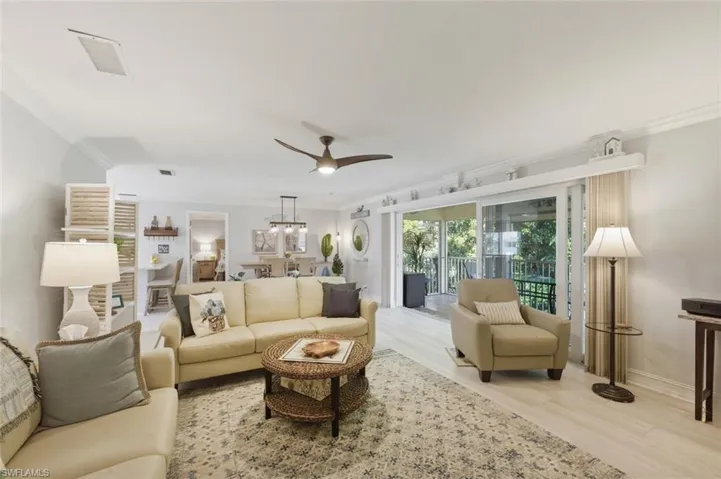 Living area featuring ornamental molding, a ceiling fan, and light wood-style floors