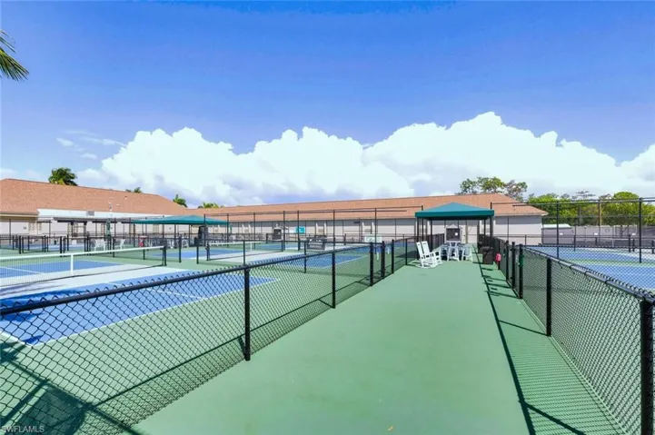 View of tennis court featuring a patio area