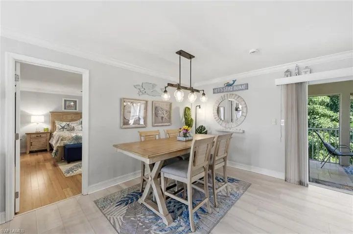 Dining space with crown molding and light wood-style flooring