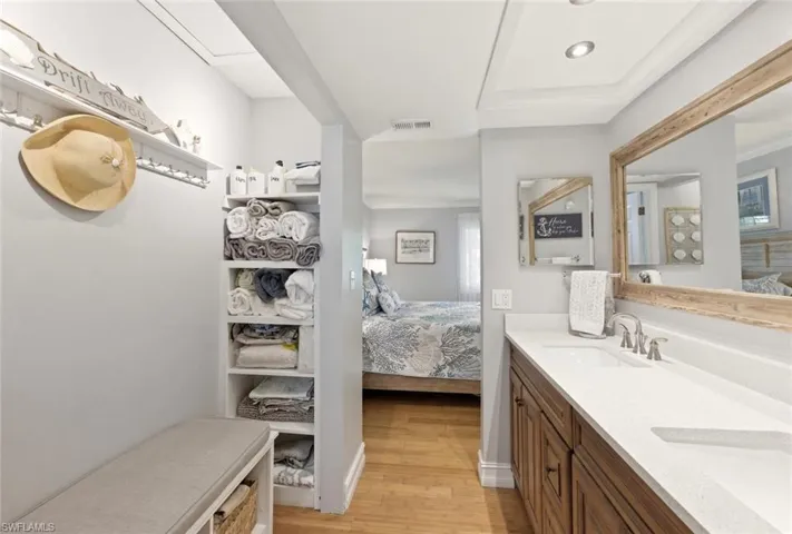 Ensuite master bathroom featuring double vanity and light wood finished floors