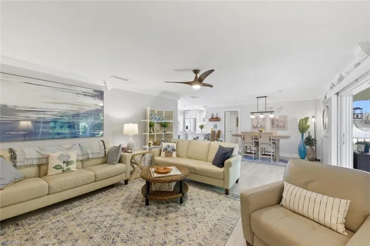Living area featuring ceiling fan, crown molding, and wood finished floors