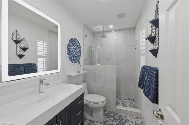 Guest Bathroom with vanity, a walk in shower, and tile patterned flooring