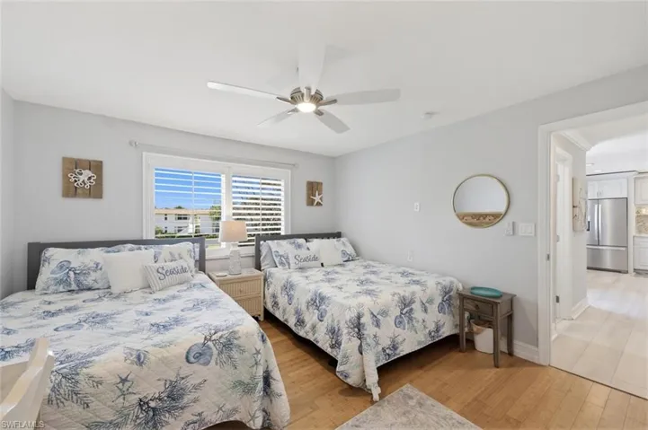Guest Bedroom featuring stainless steel refrigerator with ice dispenser, light wood finished floors, and a ceiling fan