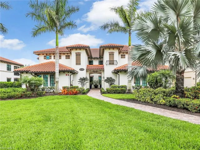 Mediterranean / spanish house with stucco siding, a front yard, and a tiled roof