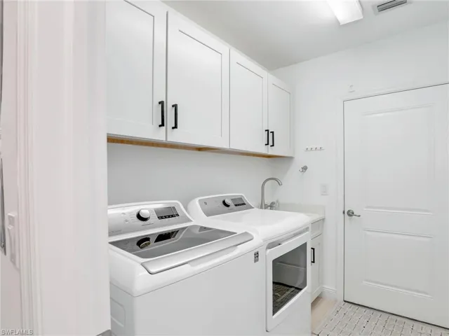 Laundry room with washer and clothes dryer and cabinet space